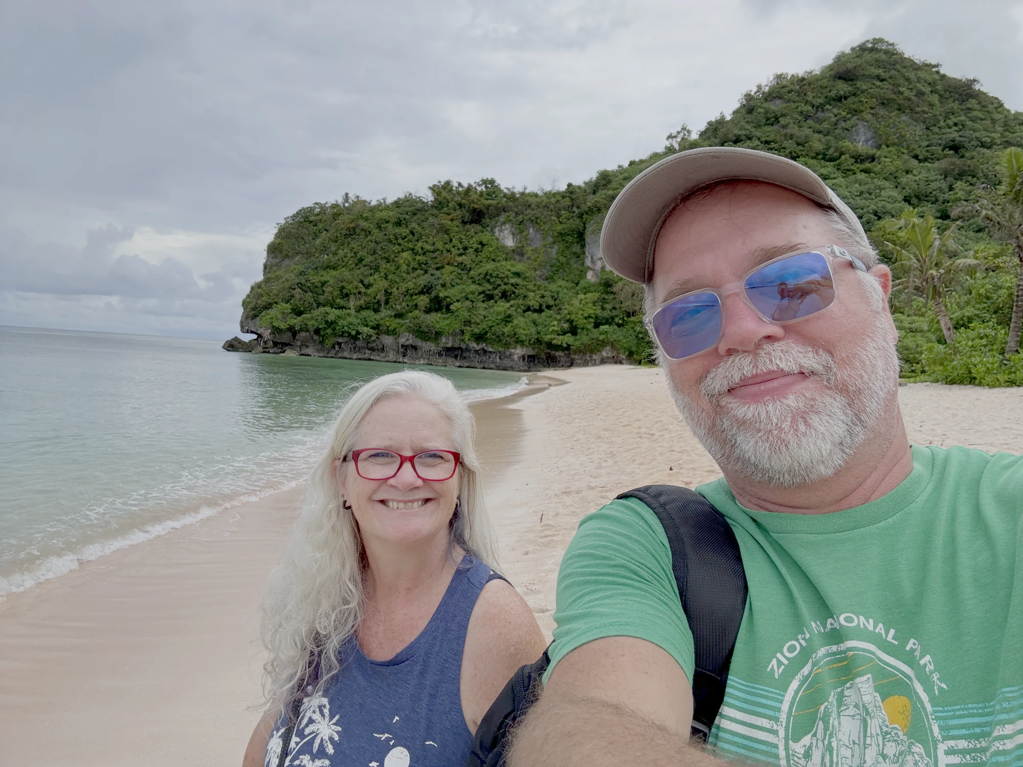 Russ and Sherri smiling together on a tropical beach in Guam
